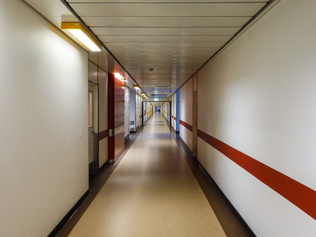 Mother of Six Sues Hospital After Hysterectomy Allegedly Led to Paralysis and Amputations Empty corridor inside a modern hospital building