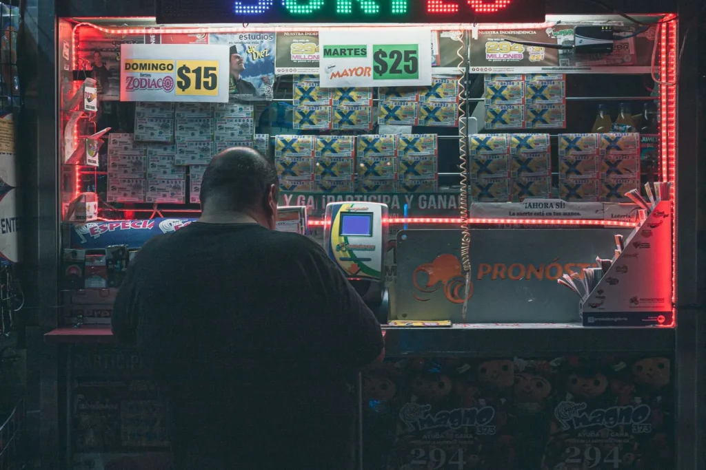 The Mechanics of a Mega Jackpot: How Powerball Built a $562 Million Prize Customer buying a lottery ticket at an illuminated kiosk in a city at night