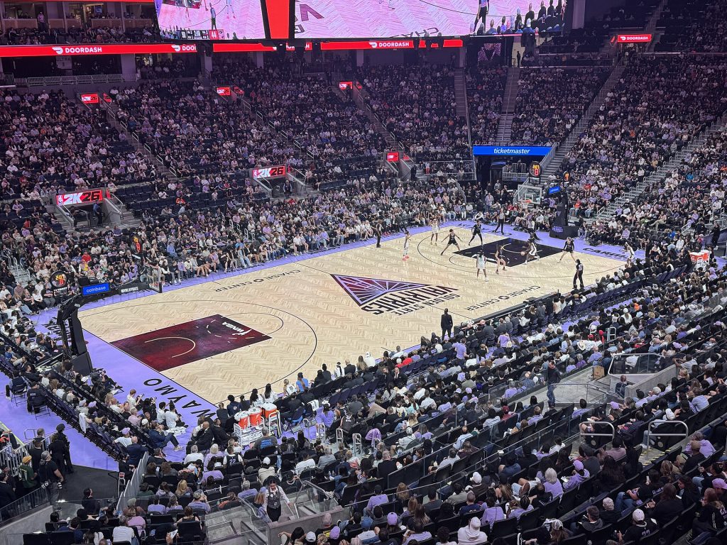 A women's basketball game in a packed indoor arena